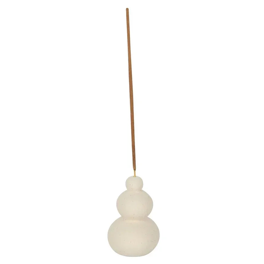 Minimalistische wierookhouder van wit keramiek met ronde vormen en een houten wierookstokje.