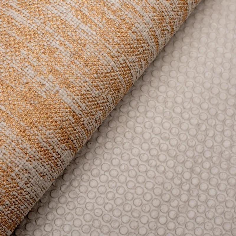 Detailopname van een geweven beige vloerkleed met antislip onderlaag
