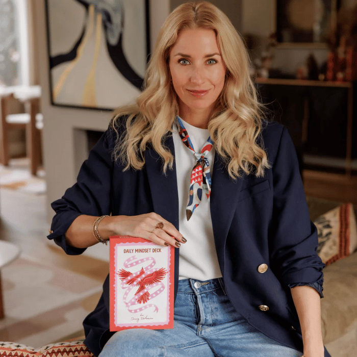Vrouw met Daily Mindset Deck kaartspel voor zelfzorg en mindfulness, perfect voor dagelijkse reflectie en rust.