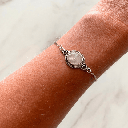 Zilveren armband met een ovale roze kristal steen om een pols