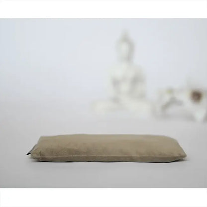 Beige meditatiekussen voor rustige yoga en mindfulness, met boeddha beeld op de achtergrond