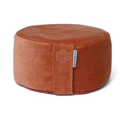 Terracotta kleurig meditatiekussen van fluweel met geborduurd klavertjevier logo
