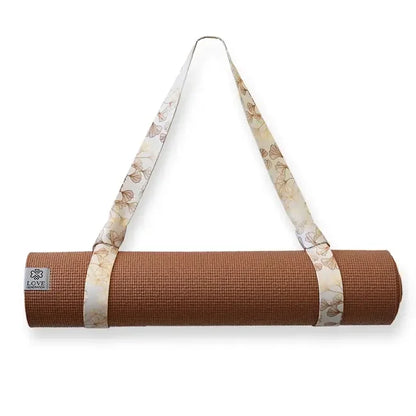 Bruine yogamat met gebloemde draagriem, ideaal voor yoga en meditatie, opgerold