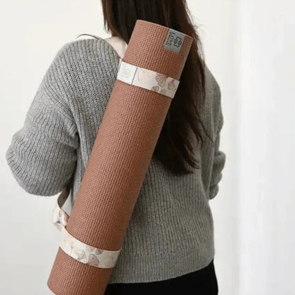 Vrouw met bruine yogamat in draagband, comfortabele outfit, meditatie en yoga accessoire