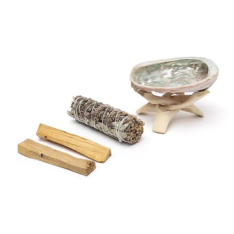Smudgeset met witte salie, palo santo en abalone schelp op standaard voor meditatie en reiniging