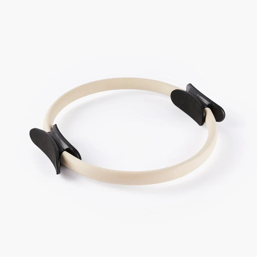 Beige pilates ring met zwarte grepen voor yoga en lichaamsbewustzijn oefeningen