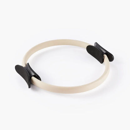 Beige pilates ring met zwarte grepen voor yoga en lichaamsbewustzijn oefeningen