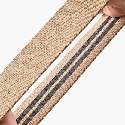 Beige yoga band met grijze strepen, ideaal voor stretching en meditatieoefeningen.