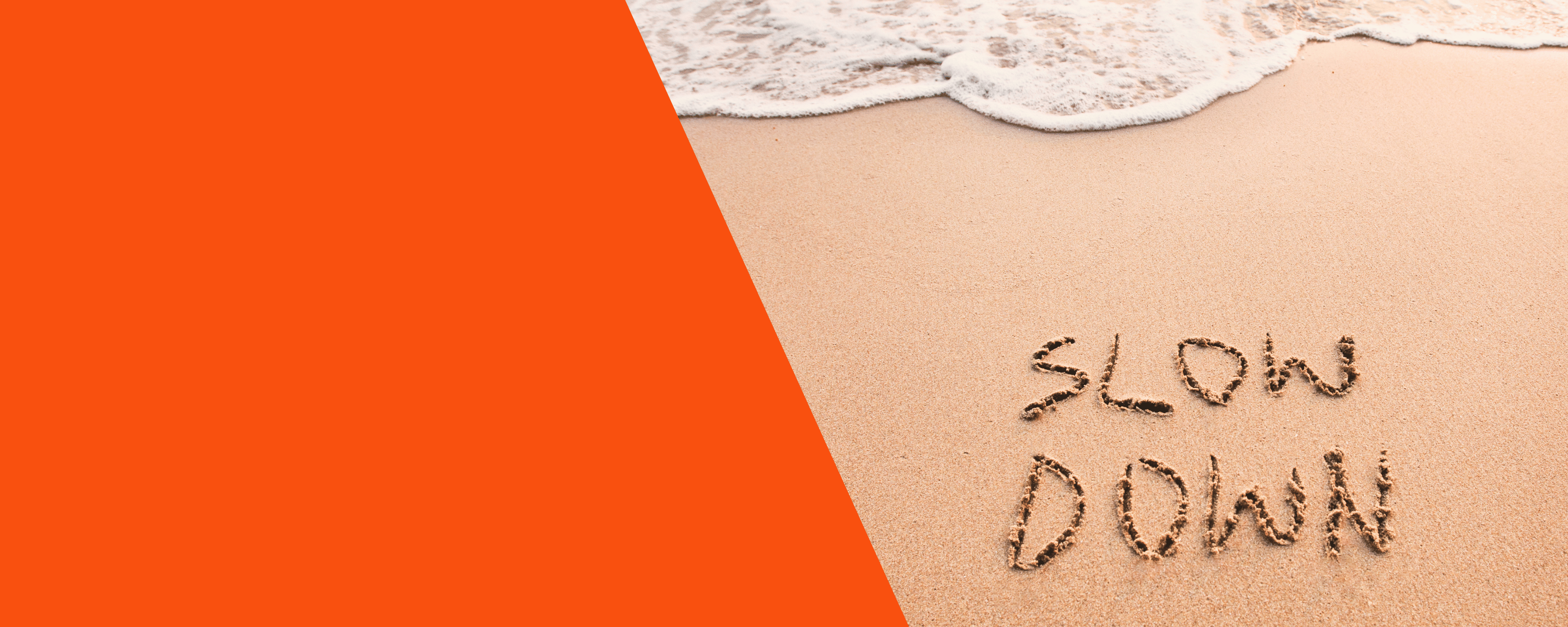 ‘Slow Down’ geschreven in het zand bij de branding, met golven en oranje achtergrond voor rust en mindfulness